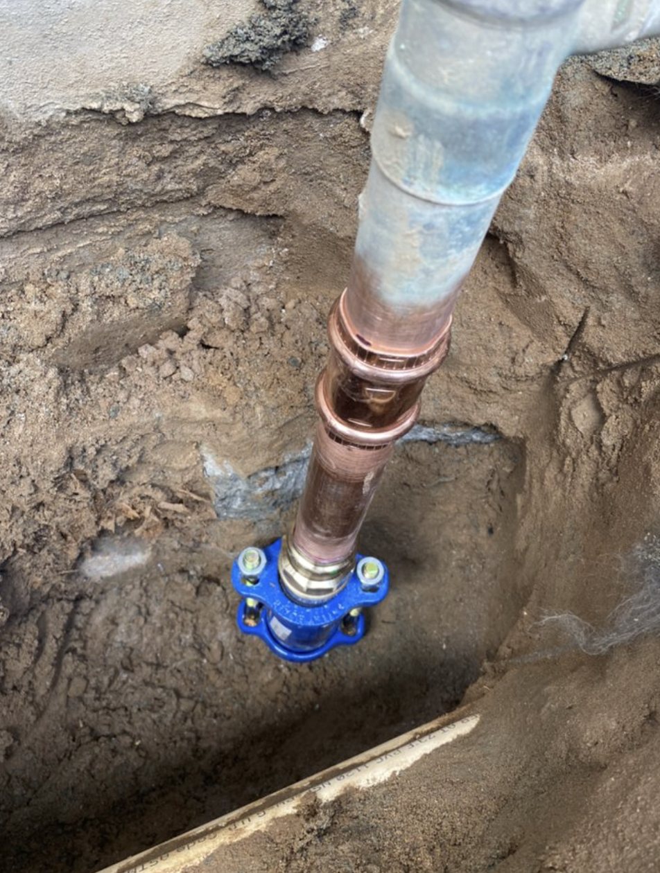 A new copper water-service line connected to a valve in an excavated trench