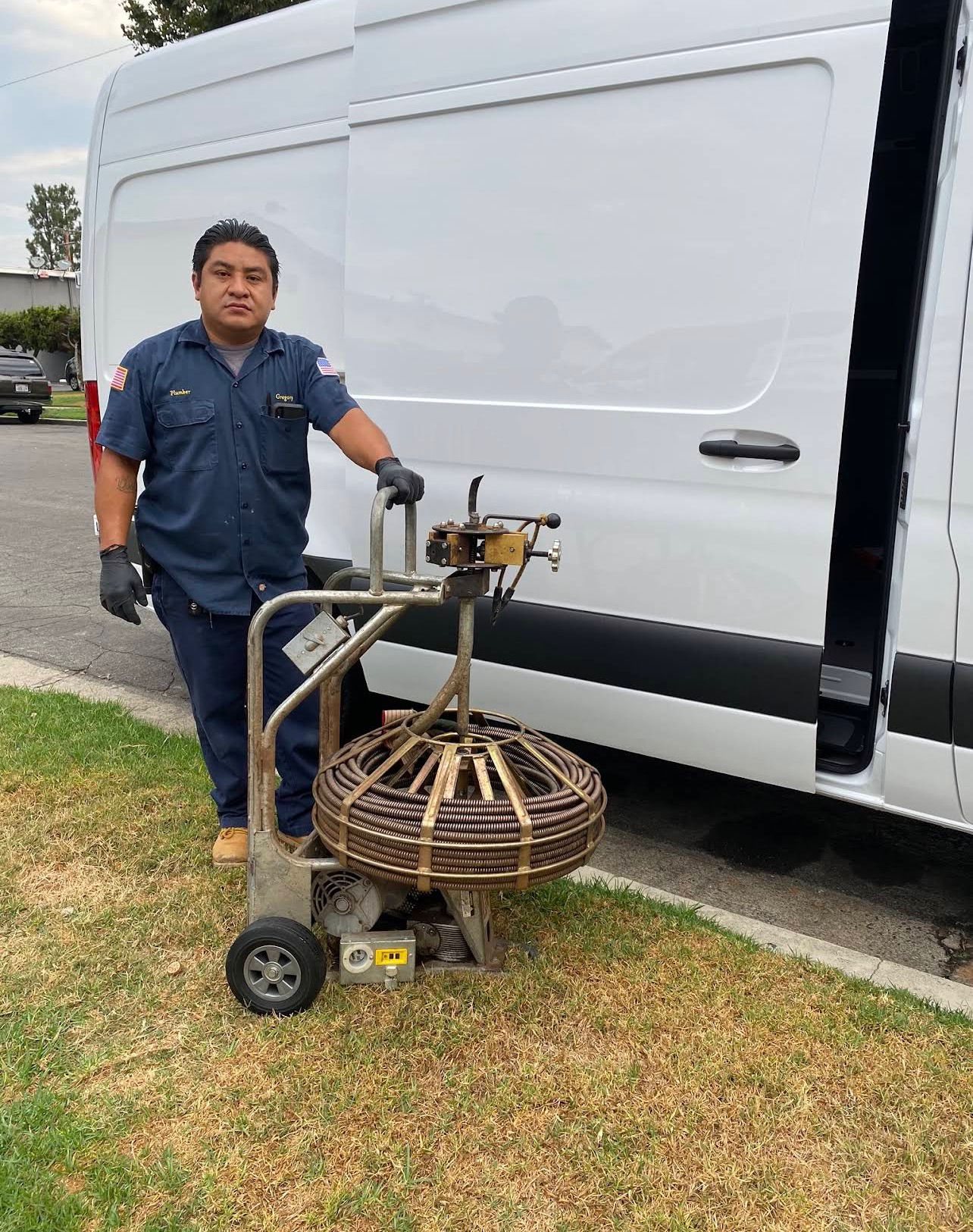 Gregorio, the owner of Geyser Plumbing, standing by his service van with his drain machine in Garden Grove